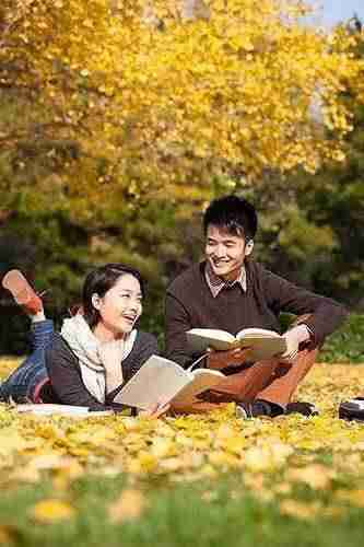 秋天校园大学生情侣与书本