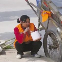 一个人蹲在路边吃饭的图片
